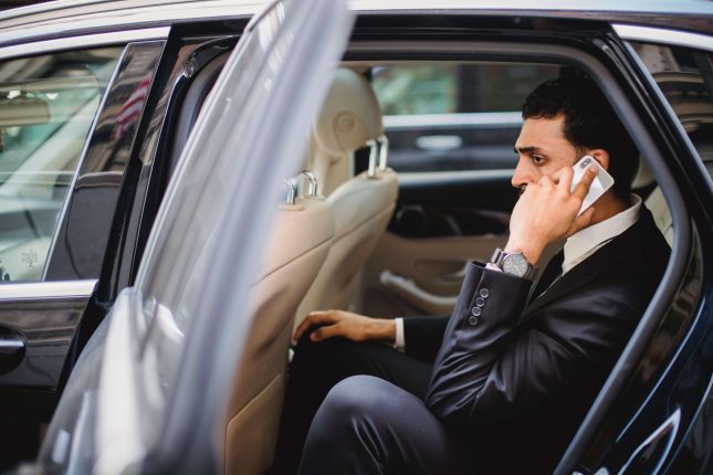 man talking on phone while in luxury vehicle